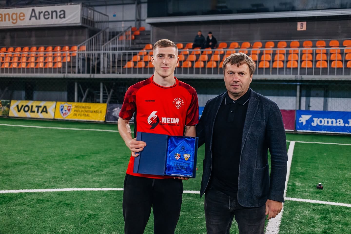 FC Red Devils player receiving an award in a red shirt featuring the 69 Media sponsor logo